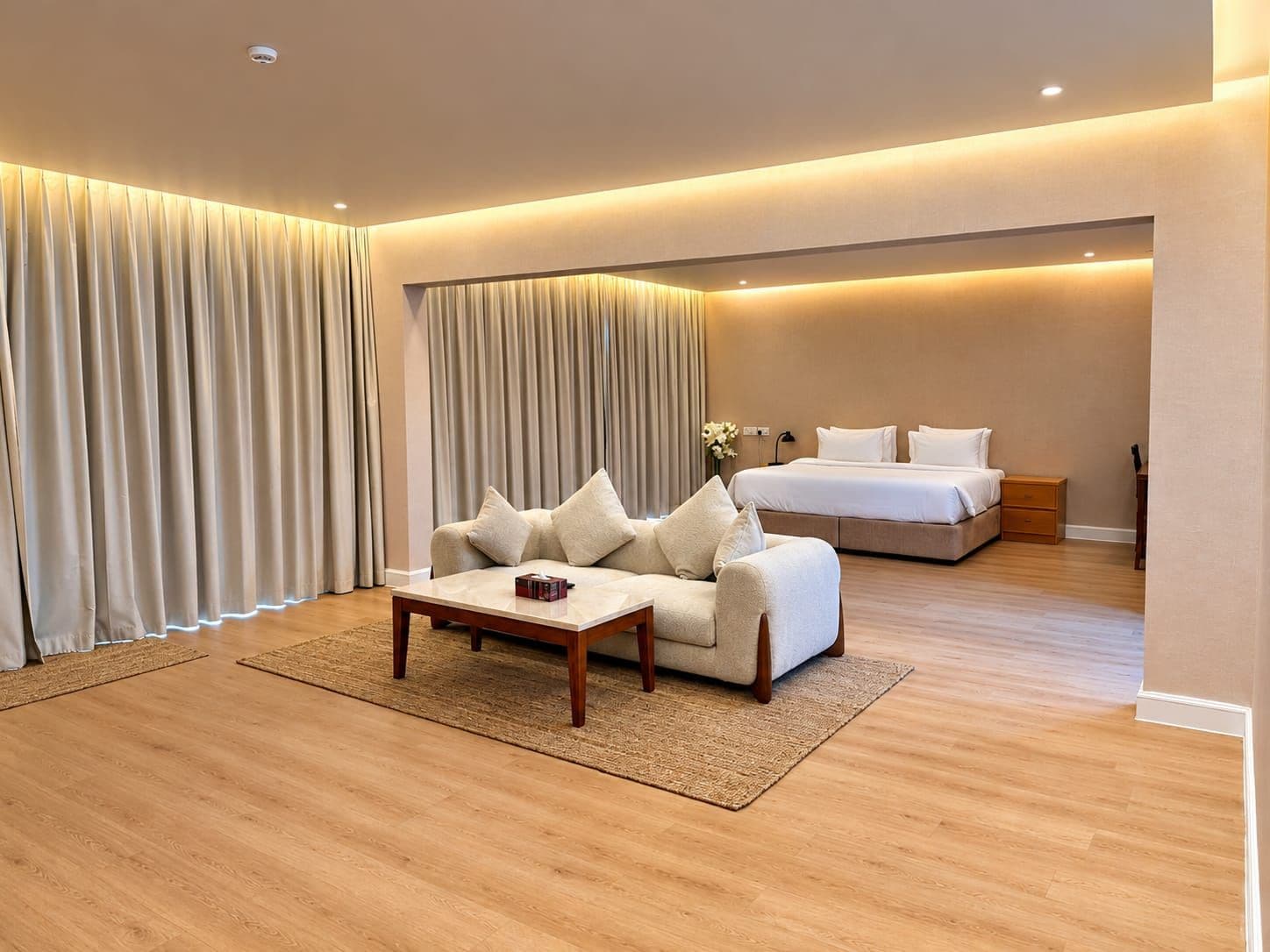 Una habitación de hotel con sofá, cama, mesita de noche y mesa de centro.