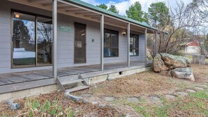 A single-story building with a covered porch, large windows, and a sign reading "Harry Stenhouse Cottage."