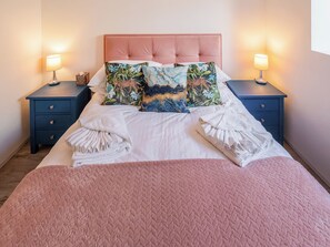 A neatly made bed with a pink quilt, two nightstands with lamps, and decorative pillows. - 3 bedroom accommodation in Cradley, near Malvern (Cradley, near Malvern)