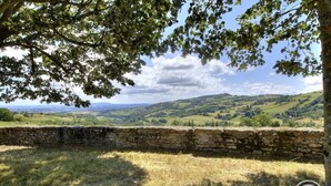 A stone wall with a view of rolling hills and a tree in the foreground. - La Maison du Crêt - RIVOLET (RIVOLET)