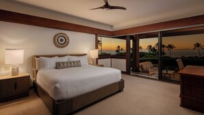 A bedroom with a large bed, a ceiling fan, a nightstand with a lamp, and a view of the ocean through a sliding glass door. - Ocean View Villa w/ Close Proximity to Ocean and Resort Amenities (Waimea)