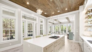 A spacious kitchen with a large island, white cabinetry, and a wooden ceiling. - "Watercolor Brushtrokes" Heated Private Pool/Golf Cart/ Walk to Camp Pool/Bikes (Santa Rosa Beach)