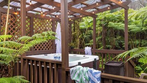 A hot tub in a wooden gazebo surrounded by lush ferns and tropical plants. - Private Rainforest Retreat in Volcano Village (Volcano)