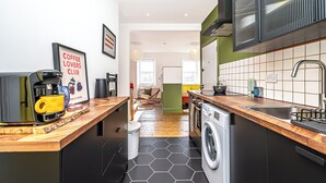 A compact kitchen with a coffee machine, a washing machine, and a sink. - Funky Studio Near The Beach (Burntisland)
