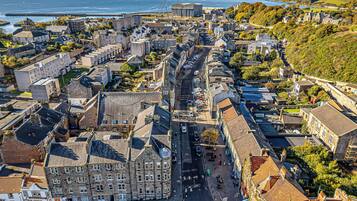 Vue aérienne d’une ville côtière avec ses bâtiments historiques, sa rue principale et son port.