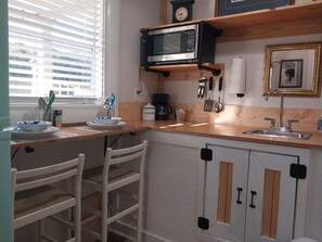 Fridge, microwave, coffee/tea maker, cookware/dishes/utensils