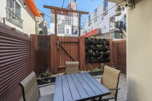 A patio with a table and chairs, surrounded by a wooden fence and potted plants. - Luxury-award winning loft Townhouse, top location (San Diego)