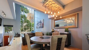 A modern dining area with a round table, four chairs, and a large window offering a view of the outdoors.