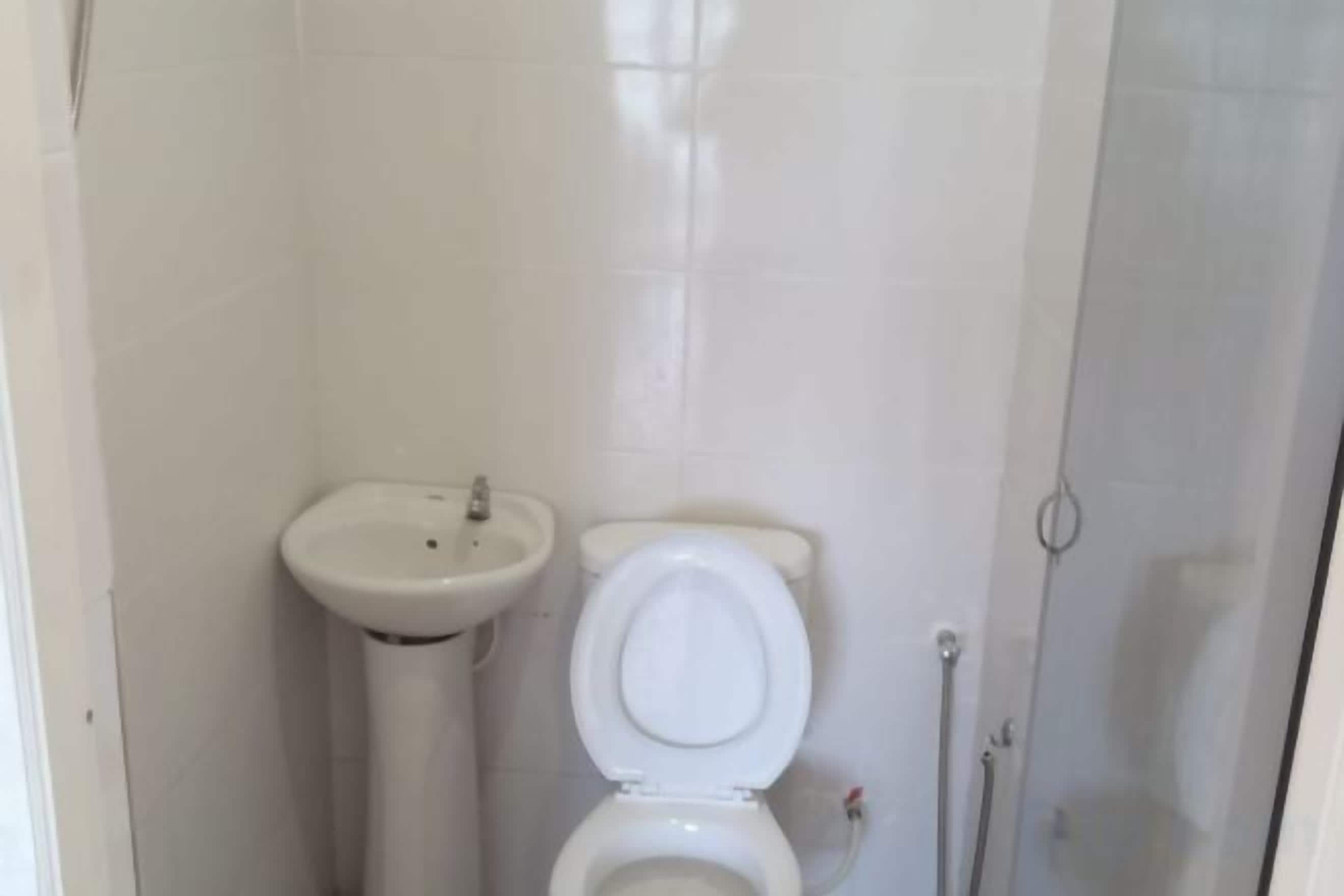 A bathroom with a toilet, sink, and shower.