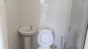 Un baño con inodoro, lavabo y ducha.