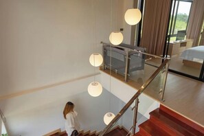 A modern interior with a staircase, a bed, and a desk area. - Krajokkaew Mouthten Khao Yai (Pak Chong)