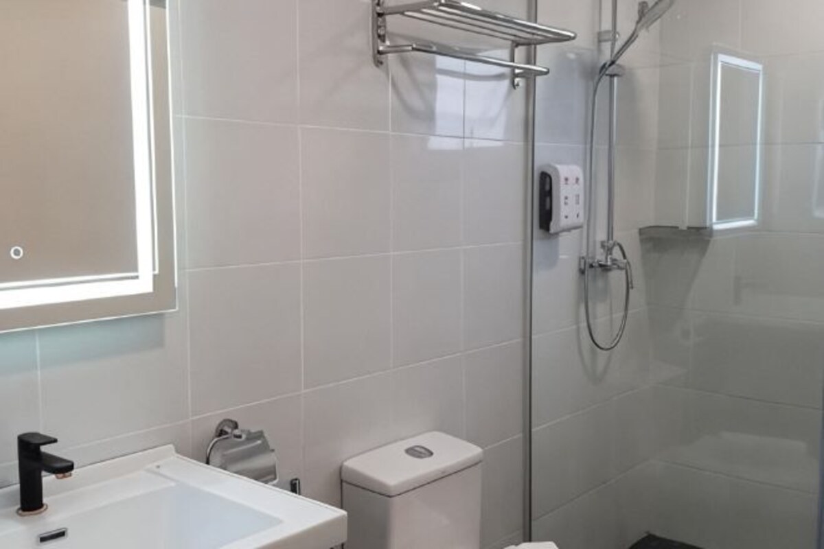 Een badkamer met een wastafel, toilet en douchecabine met glazen wanden.