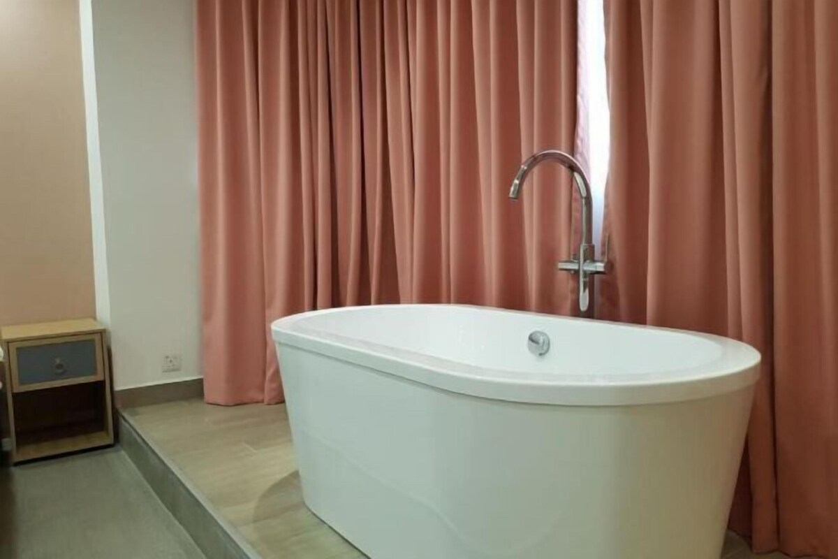 Ein Badezimmer mit einer freistehenden Badewanne, einem Wasserhahn und einem Holz-Nachttisch.