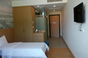 A hotel room with a bed, a wardrobe, a desk, and a television mounted on the wall. - D Arc Hotel (Donggongon)