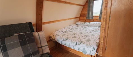 Una habitación acogedora con una cama, un sofá y una ventana con cortinas.