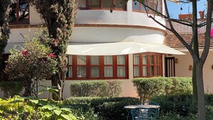 A building with a curved facade, large windows, and a white awning. - Bule Villas, 1Bed/1Bath;
El Cielito Lindo: fitness room, heated pool, WiFi  (San Francisco Tutla)