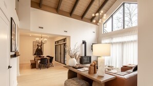 A spacious living area with a wooden dining table, a sofa, and a fireplace.