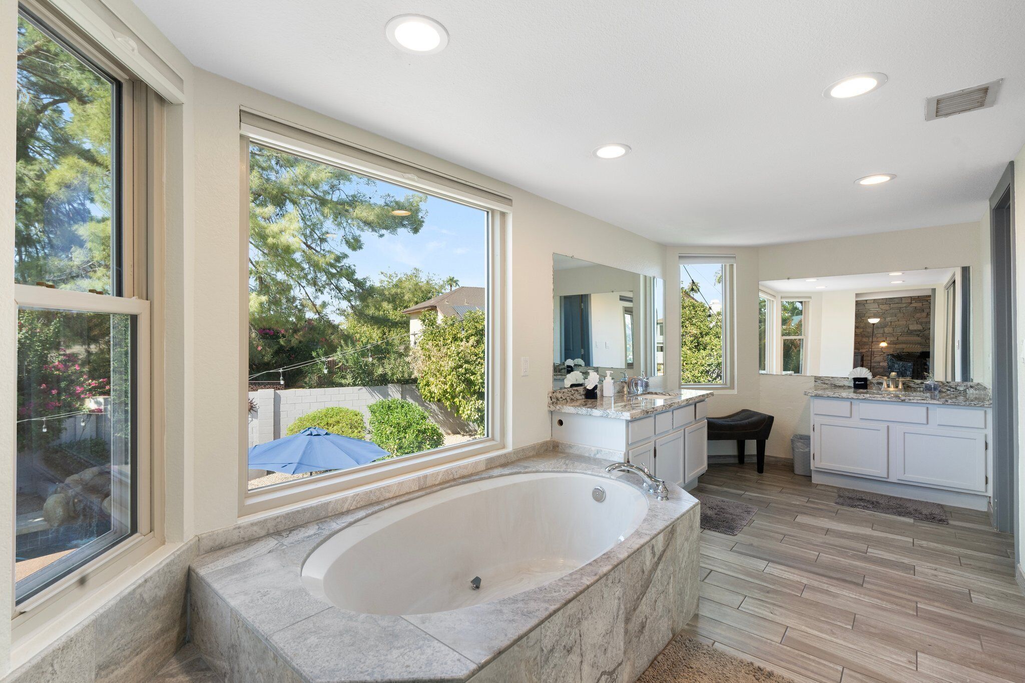 A spacious bathroom with a large bathtub, a walk-in shower, and a vanity with a sink.