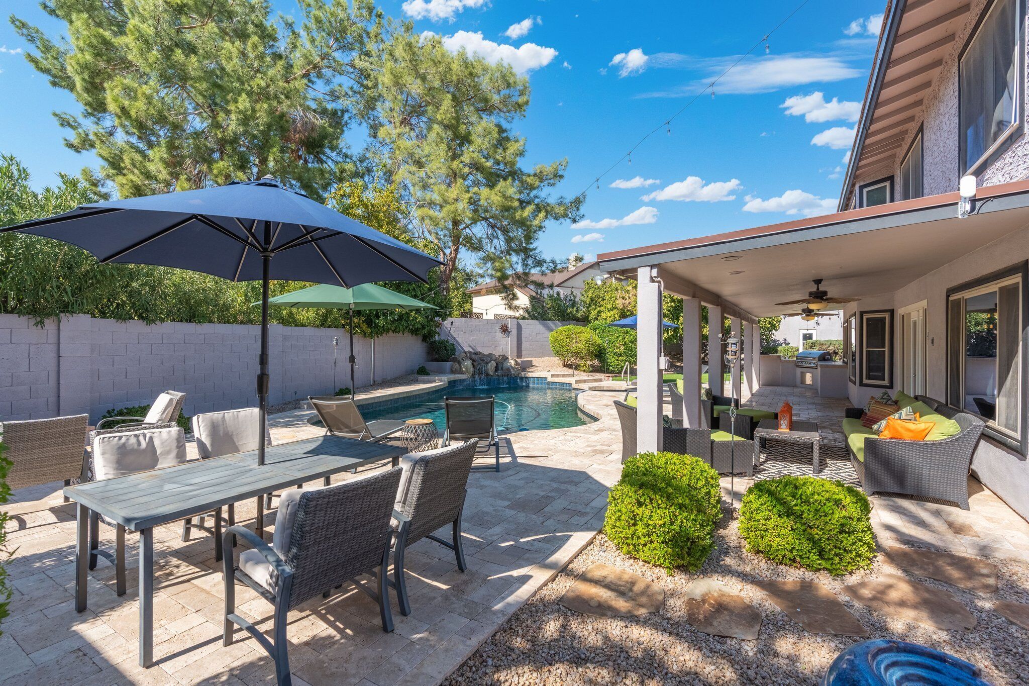Une terrasse avec une piscine, du mobilier d’extérieur et un espace salon abrité.