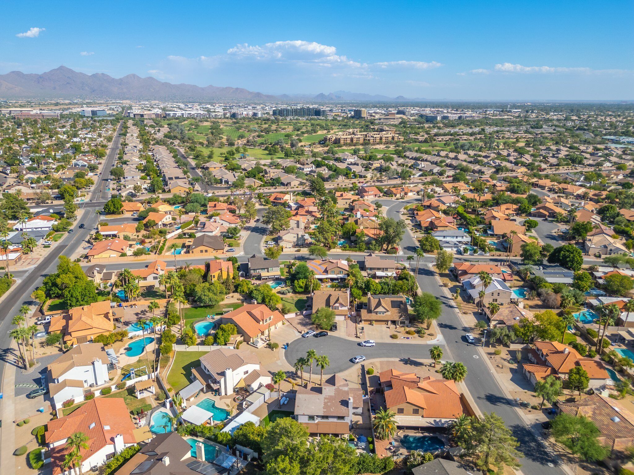 A residential area with houses, roads, and a distant mountain range.