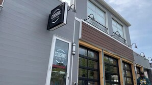 A building with a sign for Coastal Suites.