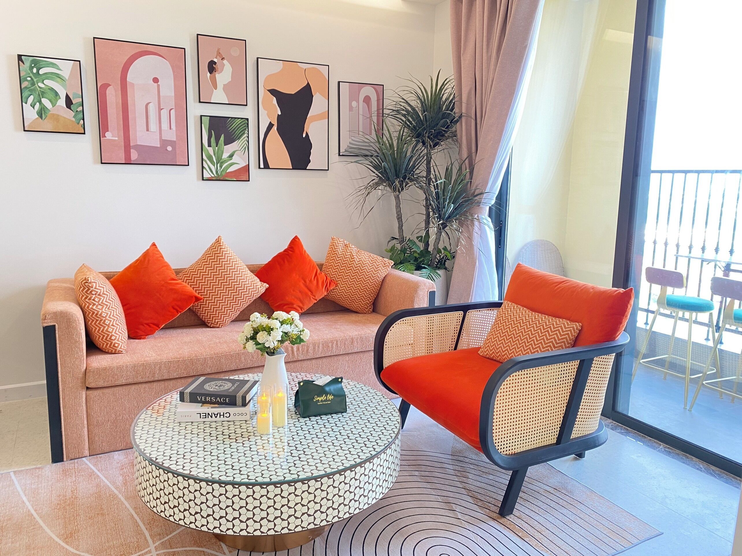 A living room with a sofa, armchair, and coffee table, decorated with cushions and framed artwork on the wall.