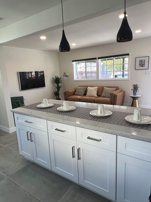A modern kitchen with white cabinets, a granite countertop, and pendant lighting. - Gated & remodeled 2b/2b house, WiFi in welcoming Baldwin Park (Baldwin Park)