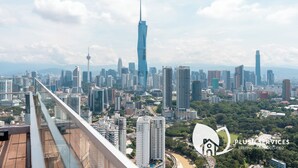 Un paisaje urbano con rascacielos modernos, incluyendo una torre destacada, visto desde un punto de altura.
