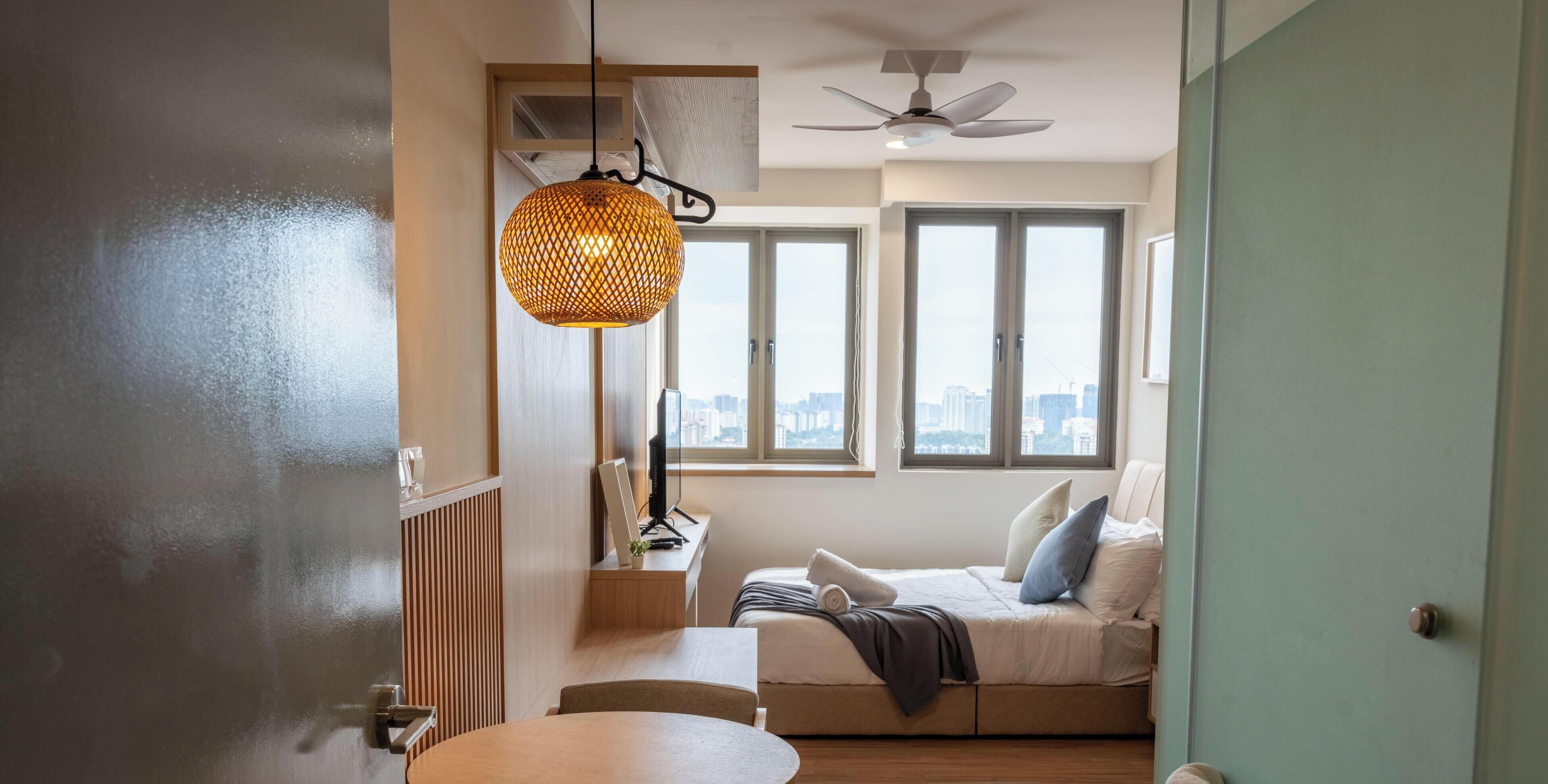 Una sala moderna con un sofá, una mesa de comedor y un ventanal con vistas a la ciudad.