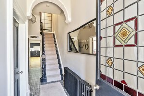 A staircase leading to a landing with a radiator below. - Victorian Beach House in Saltburn By The Sea (Saltburn-by-the-Sea)
