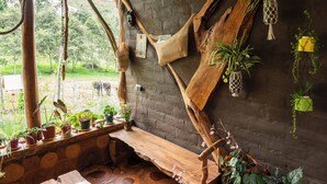 A rustic wooden interior with a stone floor, wooden bench, and various potted plants. - Amanecer Andino (Rest cabin in the mountain) (Puyo)