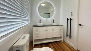 A bathroom with a white vanity, two sinks, a mirror, and a toilet. - Miami one one - Superior King Studio - Walk to Beach, Village and 2 Vineyards (Waiheke Island)