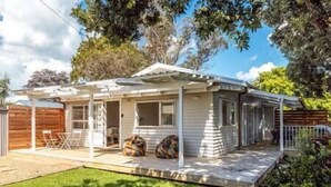 A single-story mobile home with a covered porch, a small deck, and a fenced backyard. - Miami one one - Superior King Studio - Walk to Beach, Village and 2 Vineyards (Waiheke Island)
