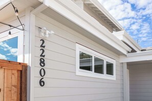 A house with the number 22806 on the side, a window, and a wooden gate.