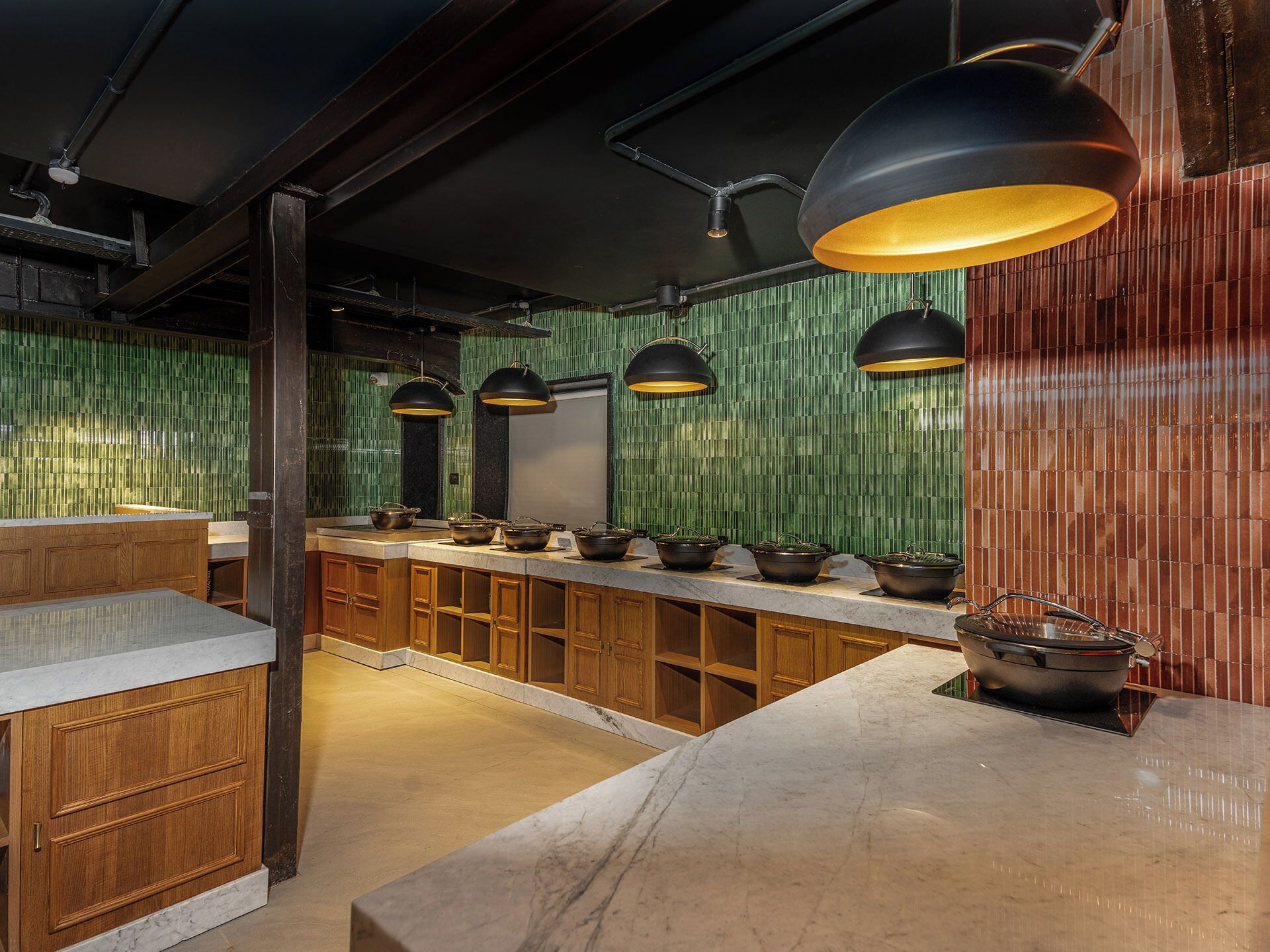A kitchen with wooden cabinets, a marble countertop, and multiple hanging pendant lights.