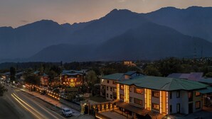 A town with buildings along a street, surrounded by mountains. - The Vale Lodge (Anantnag)