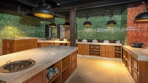 A modern kitchen with wooden cabinets, a marble countertop, and green-tiled backsplash. - The Vale Lodge (Anantnag)