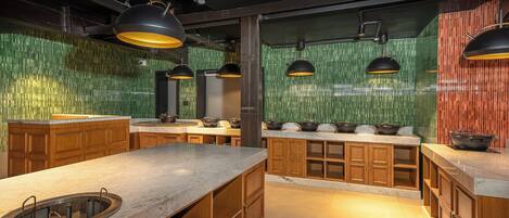 A modern kitchen with wooden cabinets, a marble countertop, and green-tiled backsplash.