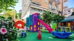 A children's play area with a slide, a climbing structure, and a horse-shaped toy. - HOTEL KONRAD (Rimini)