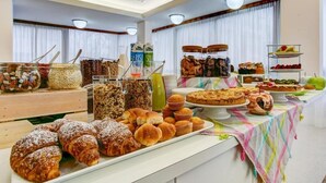A buffet with various food items including pastries, breads, and desserts. - HOTEL KONRAD (Rimini)