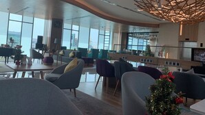 A modern hotel lobby with a curved ceiling, large windows, and contemporary furniture. - The Wellington-Republic Plaza Airport (Ho Chi Minh City)