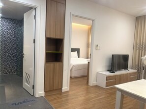 A hotel room with a bed, a TV, a desk, and a wardrobe. - The Wellington-Republic Plaza Airport (Ho Chi Minh City)