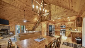 A spacious log cabin interior with a dining area, kitchen, and living room. - Private Cozy Cabin w/ Hot Tub in Blue Ridge! (Blue Ridge)