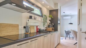 A modern kitchen with wooden cabinets, a black countertop, and a window above the sink.