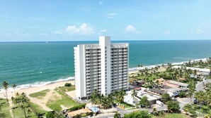 Un hotel de gran altura con varios balcones con vista a una playa y al océano.