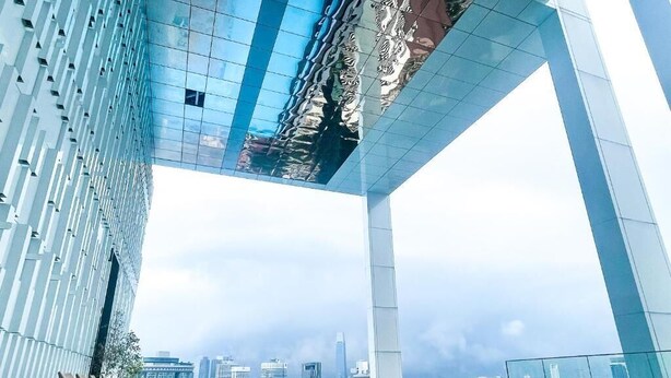 A modern building with a reflective glass facade, a rooftop pool, and a view of the city skyline. - Platinum 2 KLCC By Natol Chain Of Homestays (Kuala Lumpur)
