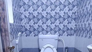 A bathroom with a toilet, a sink, and a shower.