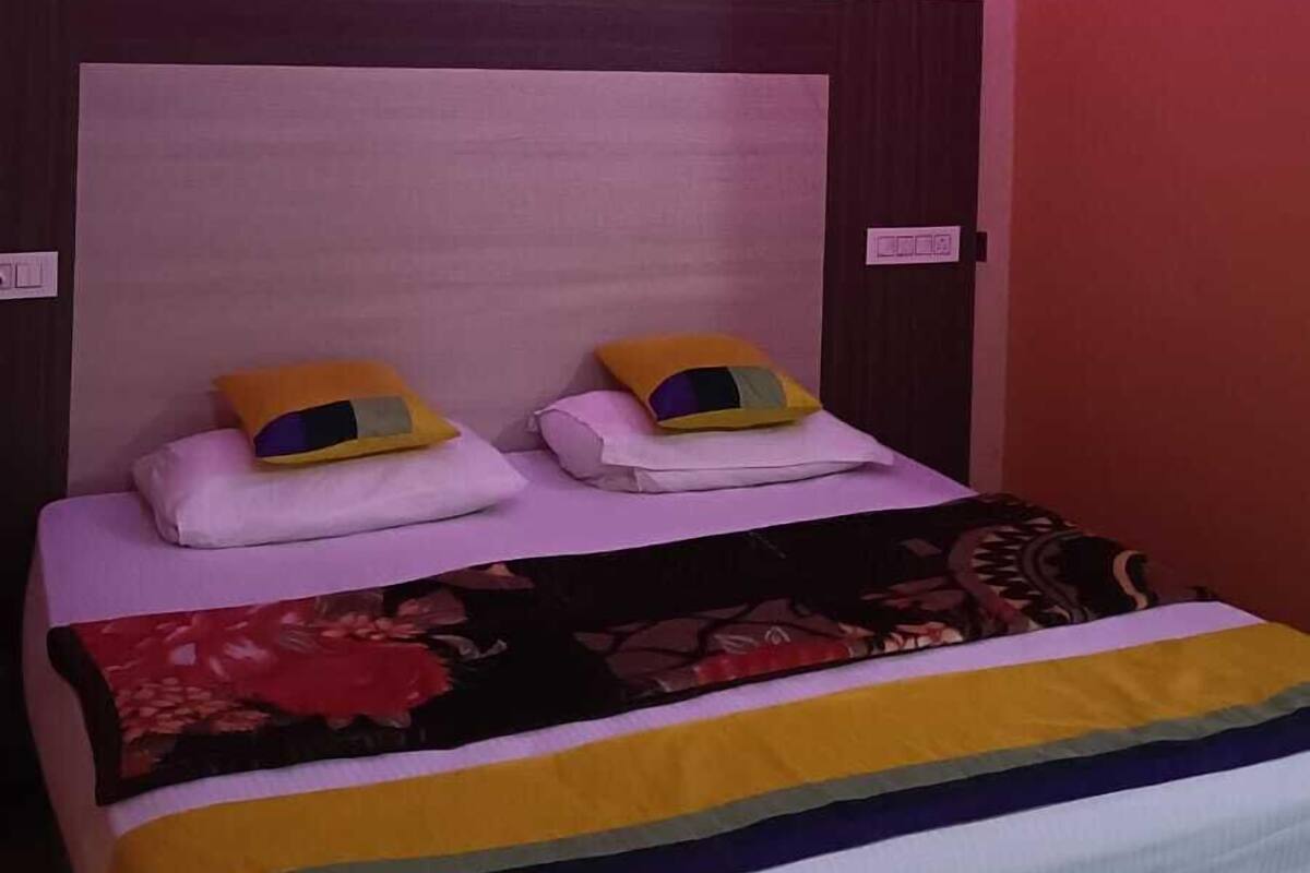 Una cama con cabecera, almohadas y una colcha.