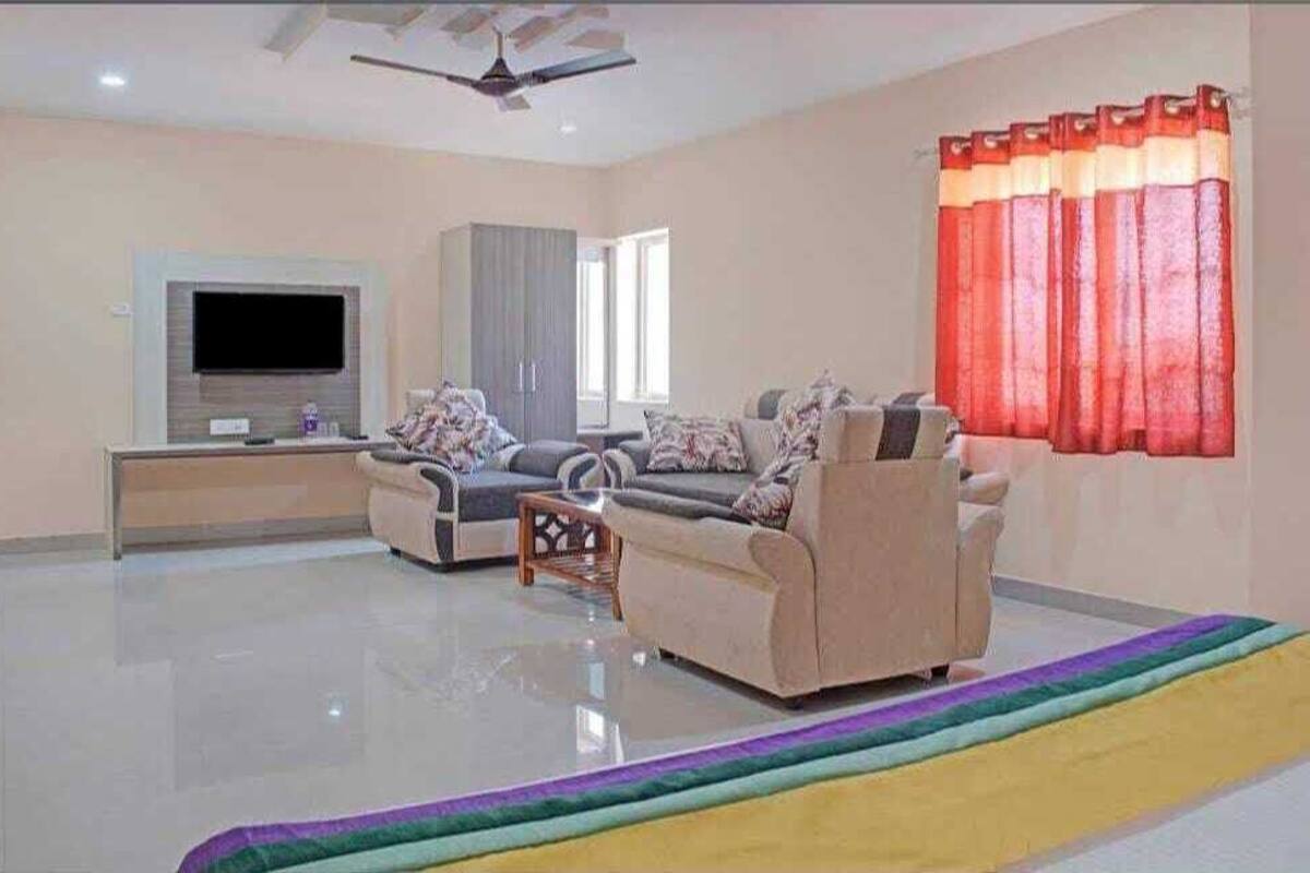 Amplia sala de estar con un televisor de pantalla plana, dos sofás, una mesa de centro y un ventilador de techo.