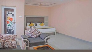 A hotel room with a bed, a chair, and a small table.